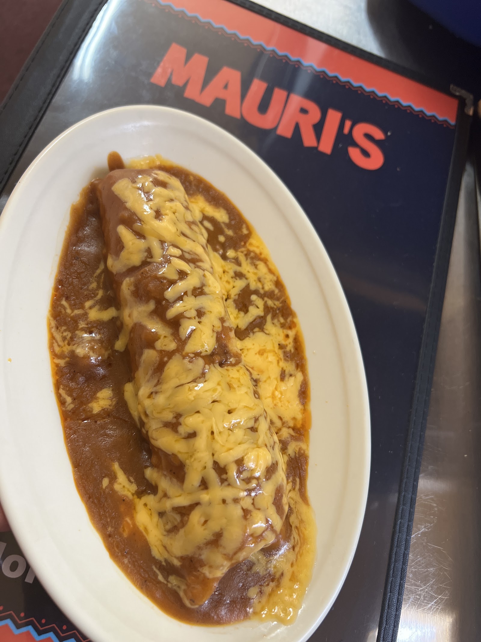 Smothered burrito topped with melted cheese at Mauri's